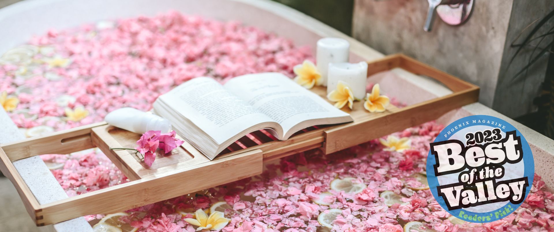 bathtub full of flower petals with a book bench across the tub