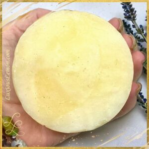 A large shave & shampoo bar in the palm of a woman's hand