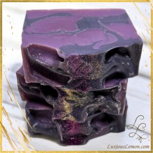 Handcrafted Blackberry Wine Goat Milk Soap bar with deep purple and black swirls, shimmering gold mica detail, and luxurious artisan finish.