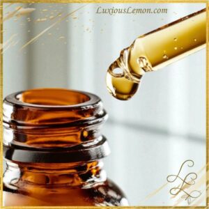 Closeup of a glass bottle of Luxious Lemon Everywear Body Oil with golden-hued oil,
